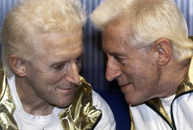 In this Dec. 17, 1986 file photo, Jimmy Savile (right) poses for photographers with a wax work model at Madame Tussauds museum in London. (AP-Yonhap News)