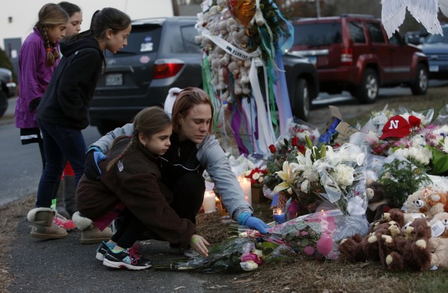 Mourners pay their respects at a memorial for shooting victims near Sandy Hook Elementary School in Newtown, Connecticut, Saturday. (AP-Yonhap News)