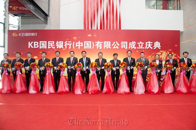 KB Financial Group chairman Euh Yoon-dae (sixth from right) and KB Kookmin Bank CEO Min Byong-deok (fourth from right) attend a ceremony to open the bank’s branch in Beijing in November. (KB Financial Group)