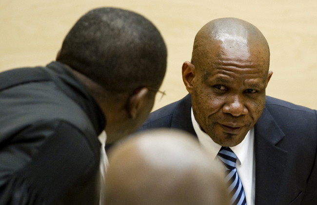 Former leader of the National Integrationist Front Mathieu Ngudjolo (right) listens to his lawyer prior to his verdict at the International Criminal Court in The Hague, Netherlands, Tuesday. (AP-Yonhap News)