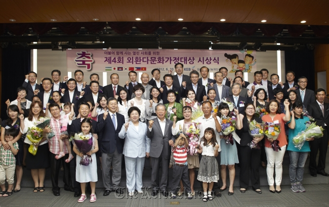 Korea Exchange Bank CEO Yun Yong-ro (center, front row) along with winners and their families pose at an awards ceremony for multiethnic families, hosted by the KEB Foundation in June 2012. (Hana Financial Group)