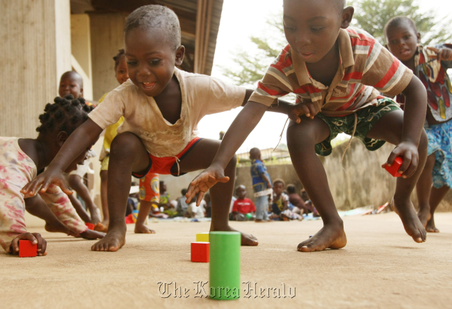 Children in the Ivory Coast play with wood blocks given by the Korean Committee of UNICEF in 2012. (The Korean Committee of UNICEF)