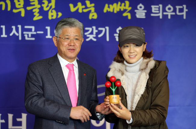 LPGA Tour golfer Choi Na-yeon (right) holds a statuette signifying her Honor Society membership she received from SKC and SK Telesys chairman Choi Shin-won (left), head of the Gyeonggi Province chapter of the Community Chest of Korea, in Seoul on Thursday. (Yonhap News)