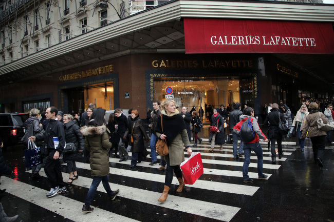 Shoppers walk past a Paris store decorated for Christmas on Dec. 20. (AP-Yonhap News)