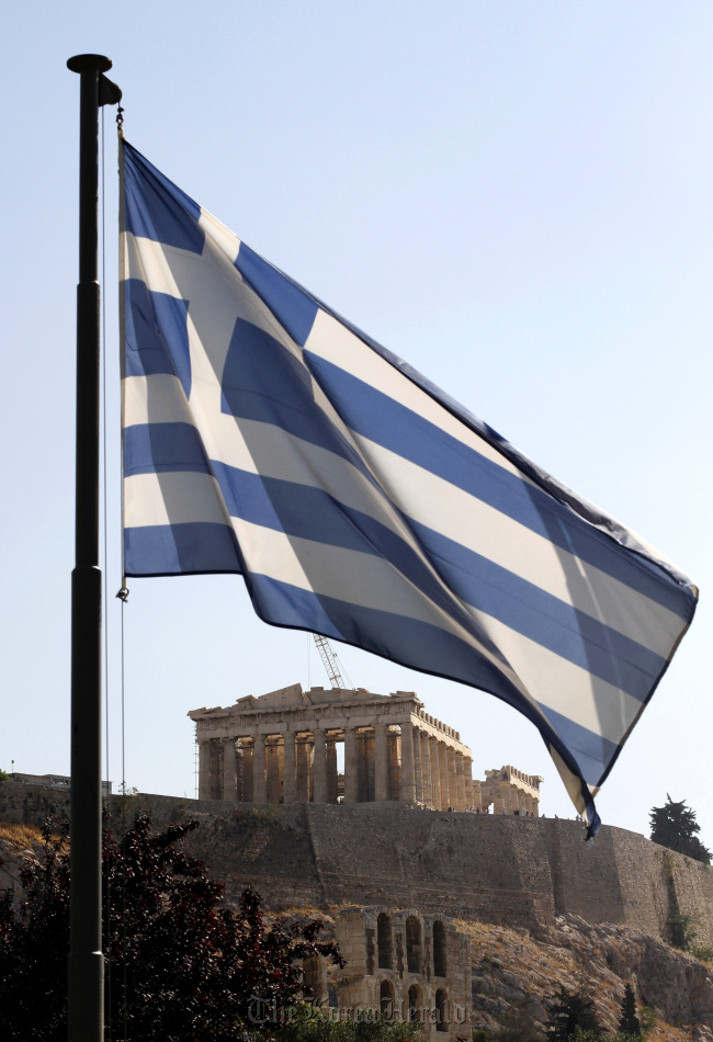 The Greek national flag flies at the foot of Acropolis hill in Athens. (Bloomberg)