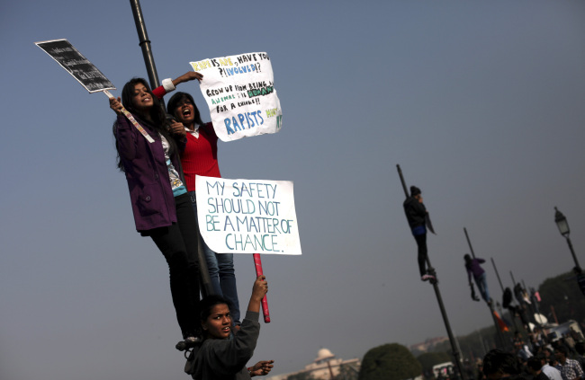 Indian women hold placards as they shout slogans from a flag post near the Presidential Palace during a protest in New Delhi on Saturday. (AP-Yonhap News)