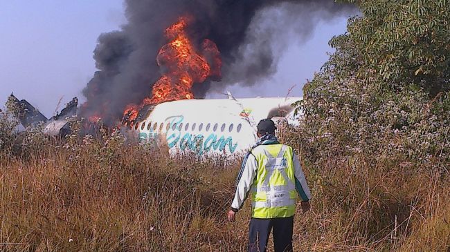 A man walks to the fuselage of an Air Bagan passenger plane burning after it crashed near Heho airport in Myanmar’s eastern Shan state on Tuesday. (AFP-Yonhap News)