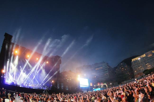 People attend a free Christmas concert as Brazilian musician Gilberto Gil performs on stage at Copacabana beach on Tuesday in Rio de Janeiro, Brazil. (AFP-Yonhap News)