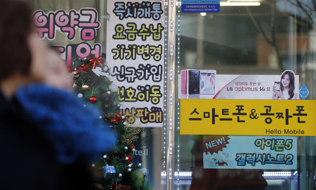 A sign on the window of a mobile phone sales outlet in downtown Seoul advertises free phones on Monday. (Yonhap News)