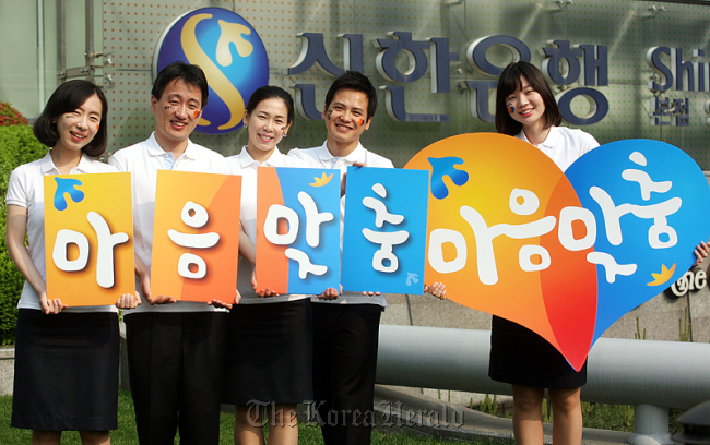 Shinhan Bank employees pose while promoting the bank’s new customized service in May in front of the bank headquarters in Seoul. (Shinhan Bank)