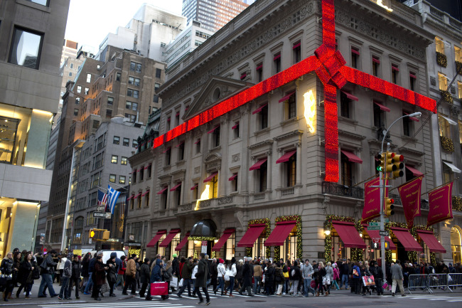 Shoppers crowd the sidewalk around the Cartier Mansion wrapped in a red bow for the holidays, on Fifth Avenue in New York on Sunday. (Bloomberg)