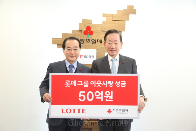 Lee In-won (left), vice chairman of Lotte Group policy headquarters, poses for a photo with Lee Dong-kurn, chairman of the Community Chest of Korea, after donating 5 billion won to the charitable fund-raiser in Seoul on Wednesday. (Community Chest of Korea)