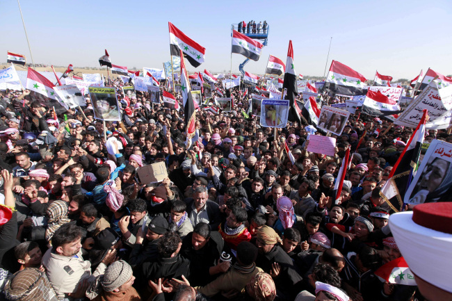 Protesters chant slogans against Iraq’s Shiite-led government as they wave national flags during a demonstration in Ramadi, 115 kilometers west of Baghdad, Wednesday. (AP-Yonhap News)