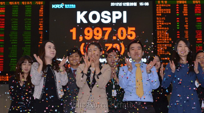 Korea Exchange employees celebrate the last trading day of 2012 at its Seoul office on Friday. (Lee Sang-sub/The Korea Herald)