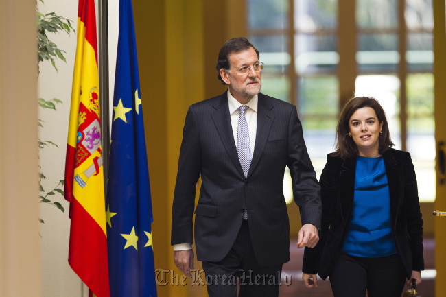 Mariano Rajoy (left), Spain’s prime minister, and Soraya Saenz de Santamaria, Spain’s deputy prime minister, arrive to attend a news conference at Moncloa palace in Madrid on Friday. (Bloomberg)