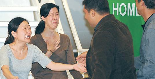 American journalists Euna Lee (left) and Laura Ling are greeted by their husbands upon arriving home in Burbank, California, after enduring an ordeal in which North Korea arrested, tried and convicted them for crossing its border with China illegally in March 2009, sentencing them to 12 years hard labor. They were released four months later only after former U.S. President Bill Clinton and former U.S. Vice President Al Gore personally intervened on their behalf in a high profile visit to Pyongyang.