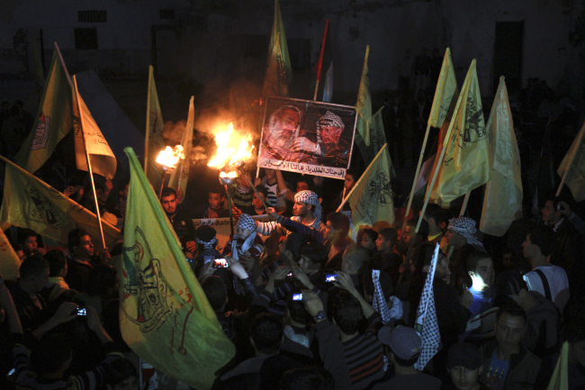 Palestinians hold torches and posters of late Palestinian President Yasser Arafat and late Hamas founder and spiritual leader Sheik Ahmed Yassin, during a rally marking the 48th anniversary of the Fatah movement in Gaza City on Monday. (AP-Yonhap News)