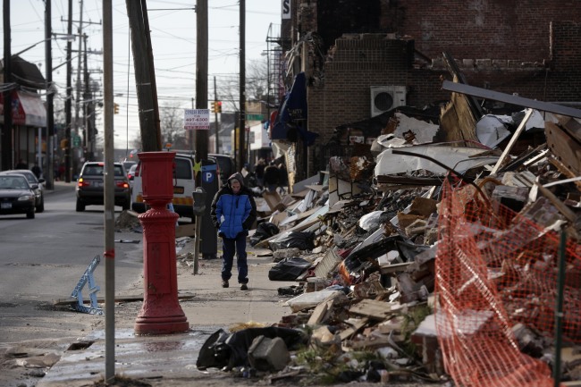 A man walks past a small commercial strip that burned down during Superstorm Sandy in the Rockaways section of New York on Wednesday. (AP-Yonhap News)