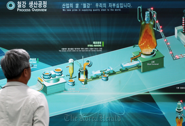 A visitor looks at a display showing an overview of the steel process at POSCO’s showroom in Seoul. (Bloomberg)