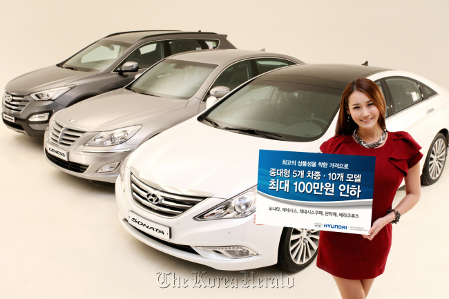 A model poses with (from left) the Santa Fe, Genesis and Sonata models of Hyundai Motor. (Hyundai Motor)