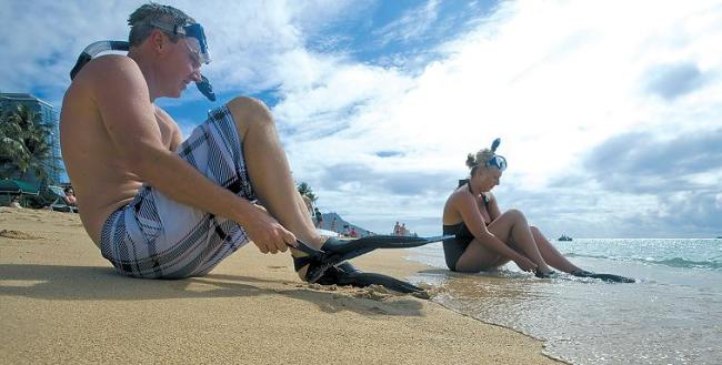 A couple prepare to snorkel in the waters off Hawaii’s Duke Kahanamoku Beach. It will be the Best Beach of 2013, according to the popular “Dr. Beach” best beaches contest that will come out around Memorial Day. (Orange County Register/MCT)