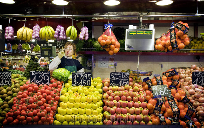 Sales assistant Anna Ribas gestures at her fruit and vegetable stall at the Boqueria market in Barcelona. (Bloomberg)