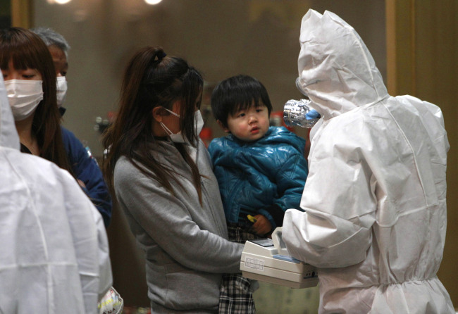 A child is screened for radiation exposure at a testing center in Koriyama city, Fukushima Prefecture, Japan, after a nuclear power plant on the coast of the prefecture was damaged by the March 11 earthquake. (AP-Yonhap News)