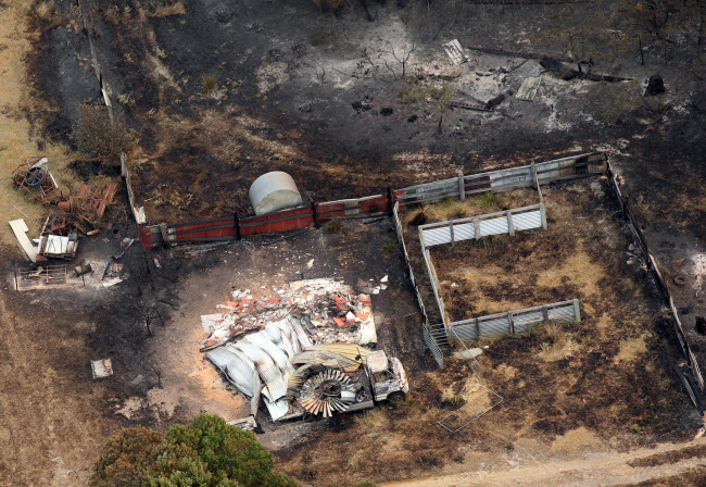 A charred vehicle sits near the remains of a home destroyed by a wildfire between Dunalley and Boomer Bay, east of the Tasmanian capital of Hobart, Australia. (AP-Yonhap News)