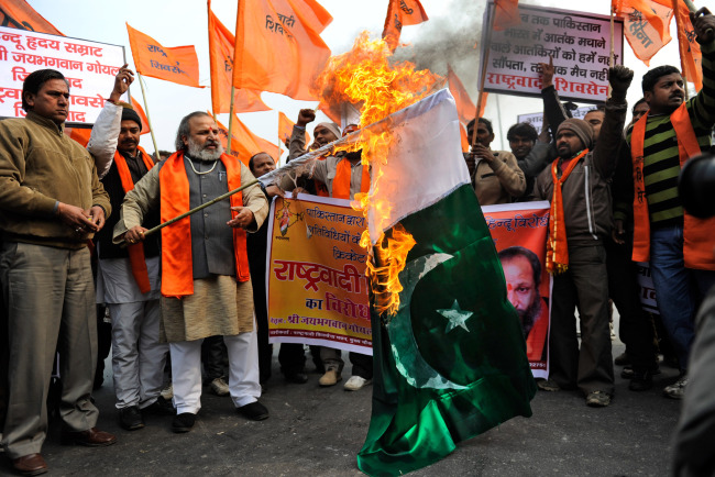 Hindu nationalist activists set a Pakistani flag on fire as they protest against Pakistan near the Feroz Shah Kotla ground in New Delhi on Sunday. (AP-Yonhap News)