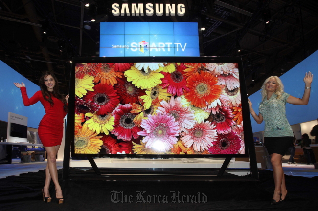 Two models present Samsung Electronics’ new 110-inch Ultra High Definition television at the Consumer Electronics Show in Las Vegas on Monday. (Samsung Electronics)