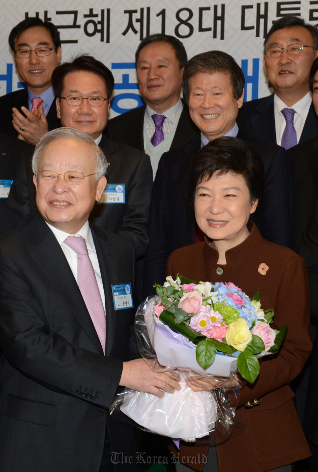 President-elect Park Geun-hye receives a bouquet from Sohn Kyung-shik, chairman of the Korea Chamber of Commerce and Industry, as she visits the KCCI for a meeting with heads of small-and medium-sized companies in Seoul on Wednesday. (Ahn Hoon/The Korea Herald)