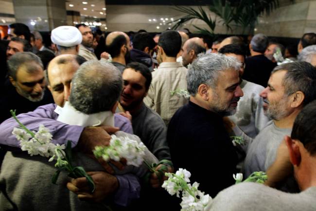 Iranian men who had been held hostage by Syrian rebels since early August congratulate each other as they arrive at a hotel in Damascus after being freed in a prisoner swap Wednesday. (AFP-Yonhap News)