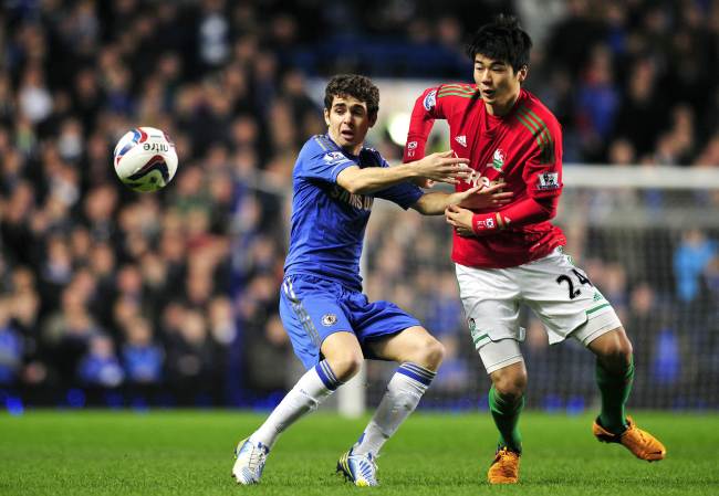 Swansea City’s Ki Sung-yueng (right) and Chelsea’s Oscar challenge for the ball on Wednesday. (AFP-Yonhap News)