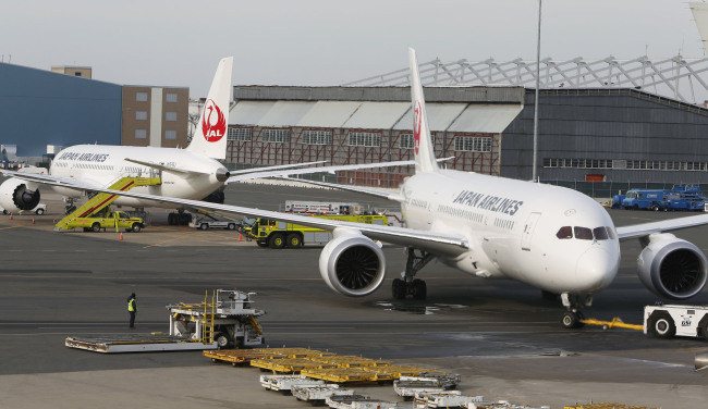 A Boeing Co. 787 Dreamliner jet operated by Japan Airlines Co., right, is towed back to the gate after a fuel leak at Logan International Airport in Boston, Massachusetts, U.S., on Tuesday. (Bloomberg-Yonhap News)