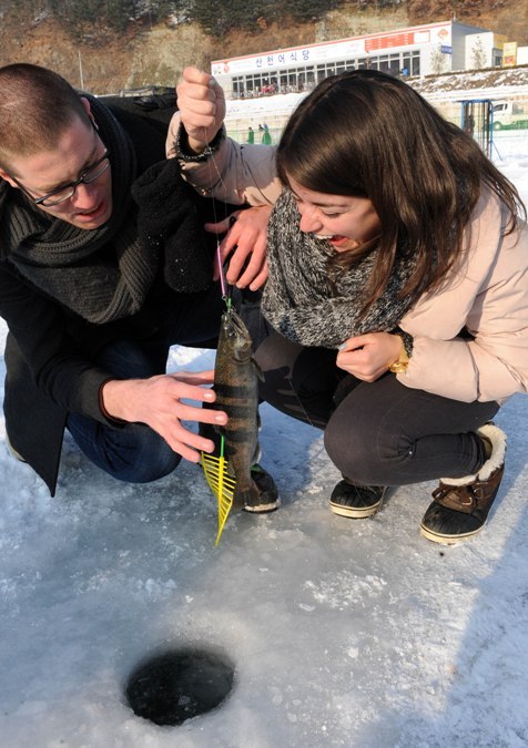 Foreign tourists fish for tro ut at the 2013 Hwacheon Sancheoneo Ice Festival. (Yonhap News)