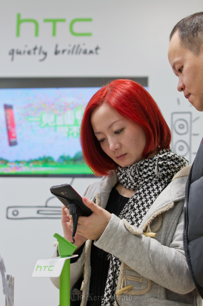 Customers try out an HTC Corp. Butterfly smartphone at one of the company’s stores in Taipei. (Bloomberg)