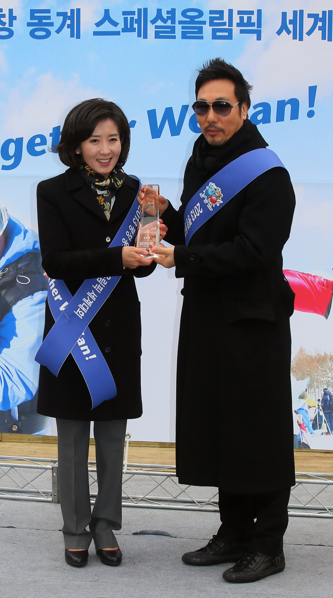 Chairwoman of the Special Olympics Organizing Committee Na Kyung-won (left) presents a plaque to singer Lee Moon-sae, who was appointed an honorary ambassador of the 2013 Special Olympics World Winter Games, at a ceremony held at Seoul Plaza on Monday. (Yonhap News)