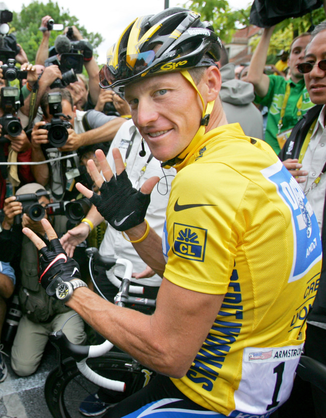 In this July 24, 2005 file photo showing overall leader Lance Armstrong, of Austin, Texas, surrounded by press photographers, signaling seven, for his seventh straight win in the Tour de France cycling race, prior to the start of the 21st and final stage of the race, between Corbeil-Essonnes, south of Paris, and the French capital. (AP-Yonhap News)