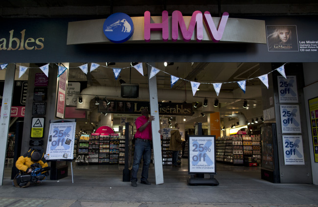 A worker opens a branch of HMV at the start of the day on Oxford Street in London, Tuesday. (AP-Yonhap News)