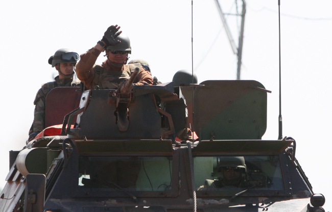 French soldiers wave as they drive near Markala, approximately 40 kilometers from Segou, in central Mali, Thursday. (AP-Yonhap News)