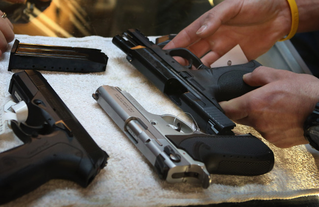 A man is choosing his own gun at the gun shop. (Yonhap News)