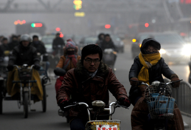 Citizens ride motorcycles amid heavy fog in Zhengzhou City, China. (Xinhua-Yonhap News)