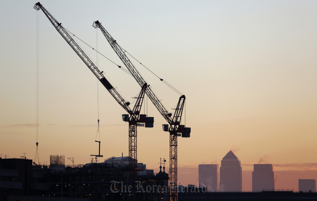 The Canary Wharf financial and business district stands on the horizon beyond construction cranes in the City district in London. (Bloomberg)