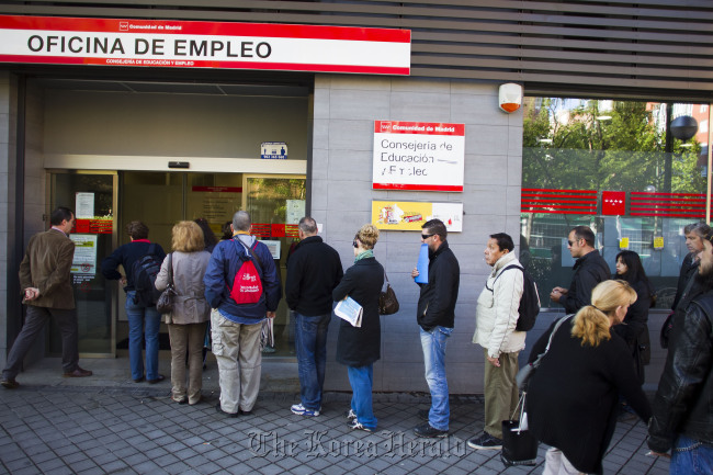 Jobseekers wait to enter an employment center after opening in Madrid. (Bloomberg)