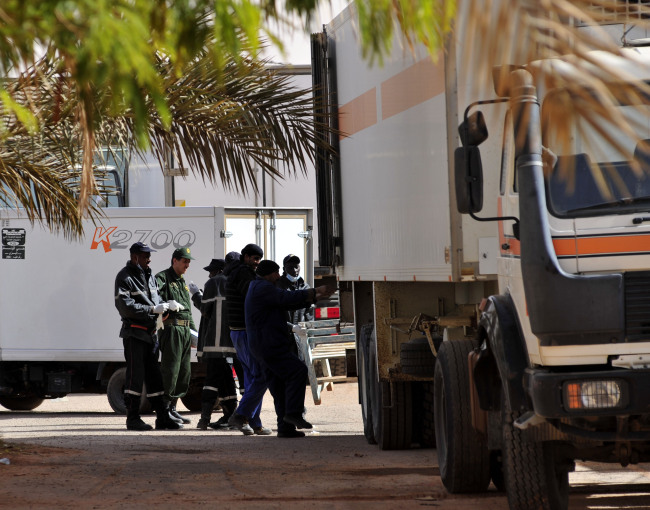 Firefighters and police officers transport bodies of victims of the hostage crisis at a hospital in In Amenas, Algeria, Monday. (Xinhua-Yonhap News)