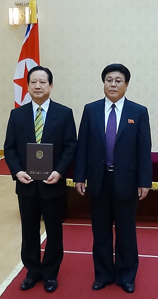 In this photograph released by Pyeonghwa Motors on Tuesday, Pyeonghwa Motors CEO Park Sang-kwon (left) poses with Cha Hui-rim, chairman of the Pyongyang City People’s Committee, at the Mansudae Assembly Hall in the North Korean capital, after receiving an honorary citizenship from Cha on Dec. 18, 2012. ( Yonhap News)