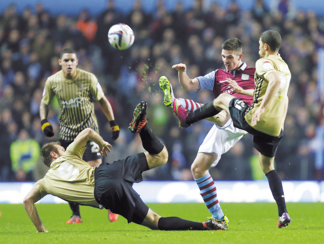 Aston Villa’s James Collins (second from right) and Bradford City’s Nahki Wells (right) and James Hanson challenge for the ball during their English League Cup semifinal in Birmingham, England, Tuesday. (AP-Yonhap News)