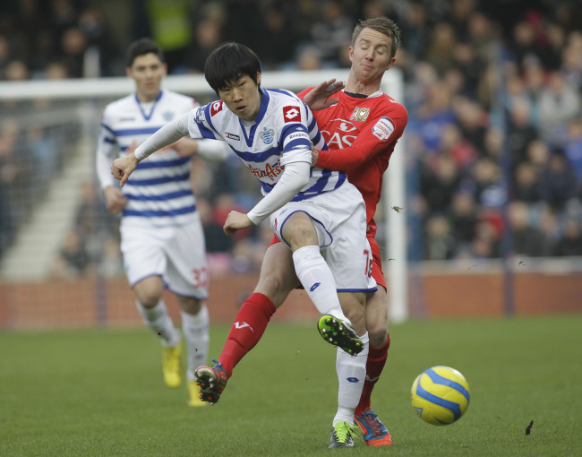 Queens Park Rangers’ Park Ji-sung competes with Milton Keynes Dons’ Dean Bowditch during their English FA Cup on Saturday. (AP-Yonhap News)