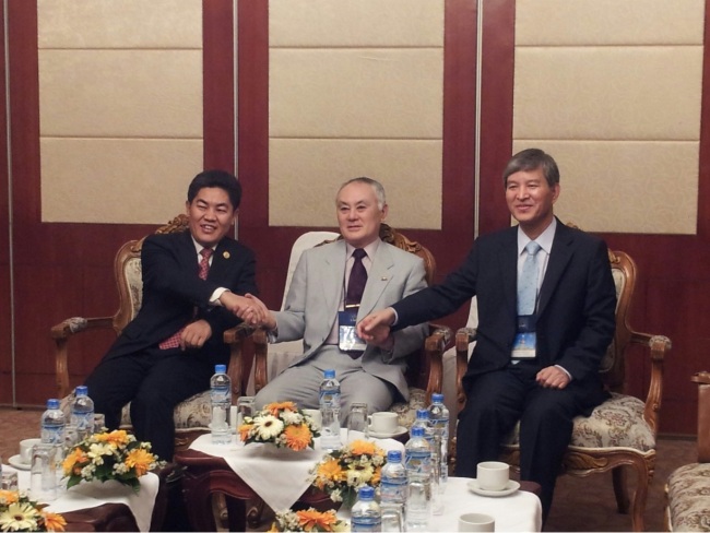 ASEAN-Korea Center Secretary-General Chung Hae-moon (right), ASEAN-Japan Center Secretary-General Yoshikuni Ohnishi (center) and ASEAN-China Center Secretary-General Ma Mingqiang clasp hands during the first three-way meeting on enhancing cooperation between ASEAN and the “Plus Three” countries in Vientianne, Laos, Jan. 20. (ASEAN-Korea Center)