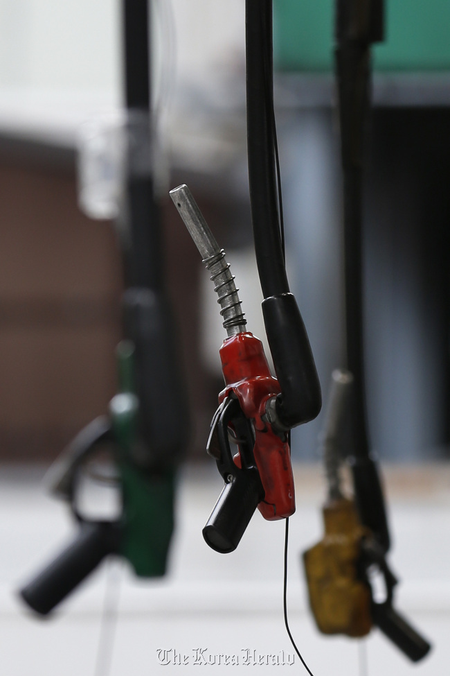 Fuel pumps hang at a gas station in Tokyo. (Bloomberg)